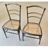 SIDE CHAIRS, a pair, 19th century Regency ebonised and gilt decorated with cane seats,