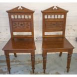 HALL CHAIRS, a pair, late Victorian walnut with pediment and incised panel backs.