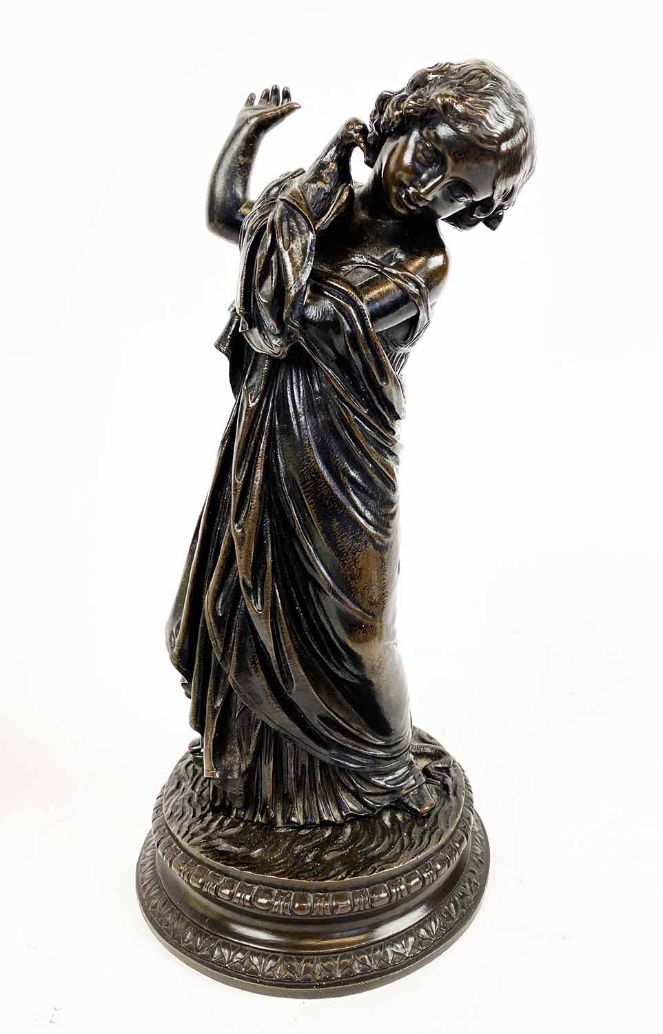 BRONZE OF A GIRL HOLDING A DOVE, stamped, '77.14', 24cm H.