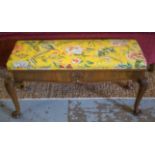 DUET STOOL, early 20th century walnut with hinged seat in yellow floral fabric, 104cm W x 42cm D.