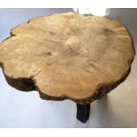 TREE TRUNK TABLE, ash tree trunk section raised upon four rustic tapered supports,