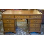 PEDESTAL DESK, Georgian style oak with brown leather top above seven drawers, 78cm H x 141cm x 72cm.