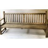 GARDEN BENCH, silvery weathered teak of slatted construction with triangle splat and flat top arms,