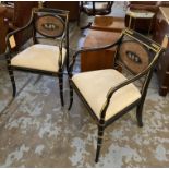 REGENCY DESIGN OPEN ARMCHAIRS, a pair, ebonised with gilt detail, caned back and painted cherubs,