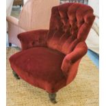 ARMCHAIR, Victorian ebonised in buttoned crimson velvet on ceramic castors, 84cm W.