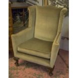 WING ARMCHAIR, late Victorian mahogany in close nailed green velvet with cushion seat and castors,