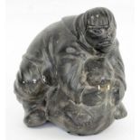 INUIT CARVING, 20th century stone, in the form of an Inuit with walrus, 23cm H.