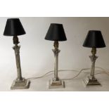 LAMPS, a set of three silver plated Corinthian capped, varying heights with shades,