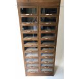 HABERDASHERY CABINET, mid 20th century English oak with twenty glazed front drawers,