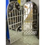 GARDEN MIRRORS, a pair, with arched metal frames, 134cm H x 63cm.