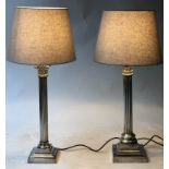 TABLE LAMPS, a matched pair, silvered Corinthian capped column lamps with stepped bases, 57cm H.