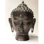THE HEAD OF BUDDHA, vintage patinated bronze with inset semi precious sapphire blue stone, 47cm.