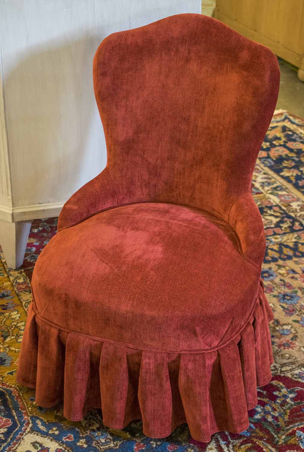 BOUDOIR CHAIR, of small proportions in red chenille upholstery with valance, 74cm H x 50cm.