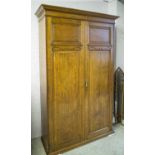 HOWARD & SONS LTD WARDROBE, late Victorian oak with two doors enclosing a shelf and hanging rail,