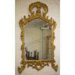 WALL MIRROR, George III giltwood with later arched plate within a scrolling rocaille border,