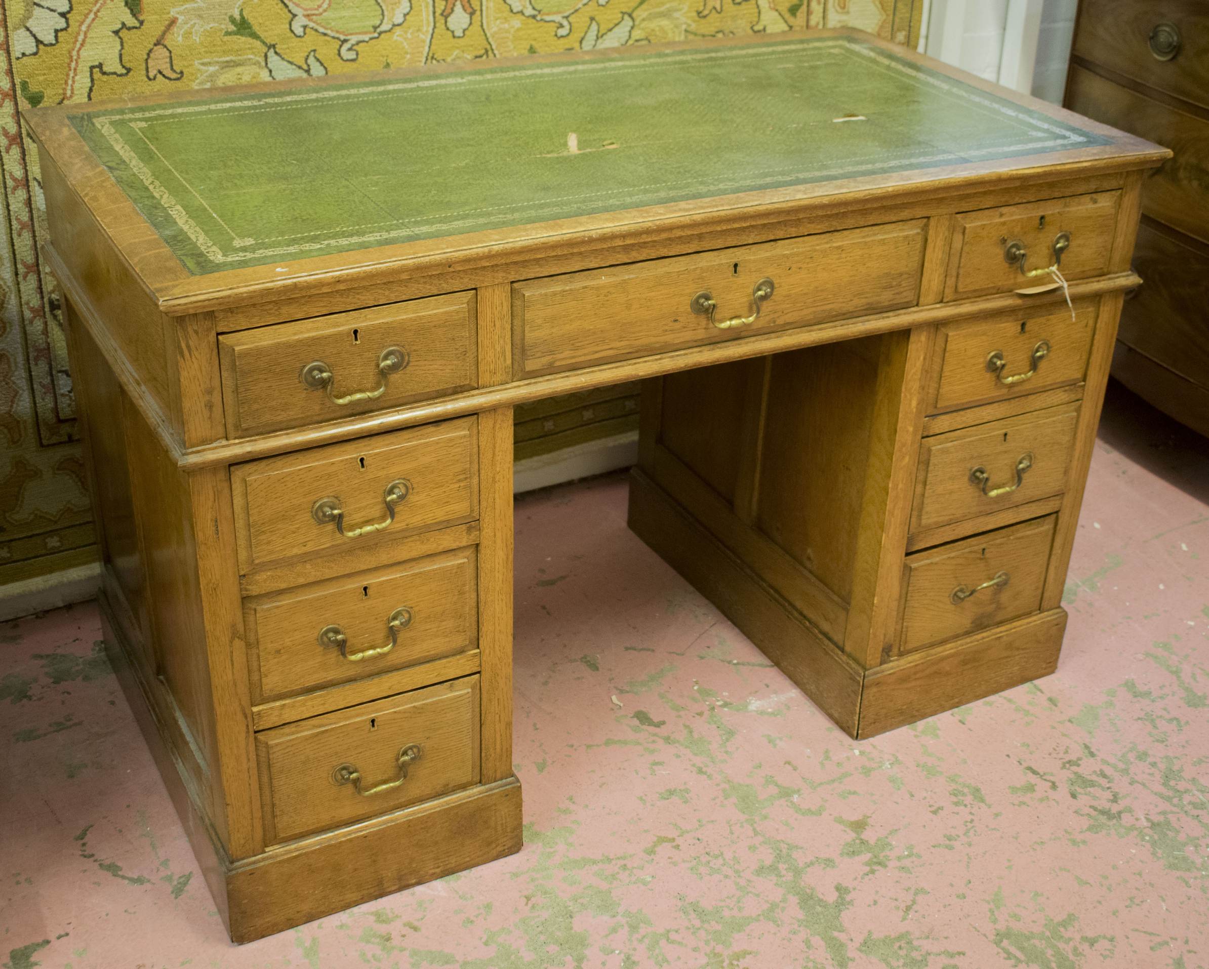 PEDESTAL DESK, late Victorian oak with tooled green leather top over an arrangement of nine drawers,