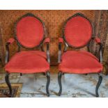 FAUTEUILS, a pair, Louis XV style ebonised with oval backs in red velvet, 56cm W.