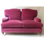 HOWARD STYLE SOFA, deep pink velvet upholstered with feather filled pads and turned front supports,