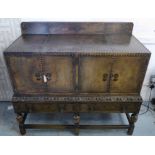 SIDE CABINET, circa 1920, studded leather and carved oak in baronial style,