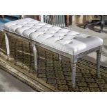 FOOTSTOOL, with a buttoned cream upholstered top on six distressed fluted supports,