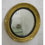 CONVEX MIRROR, Regency giltwood with a reeded black slip, 51cm W.