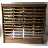 HABERDASHERY CABINET, mid 20th century oak, with four glazed sliding doors enclosing forty trays,