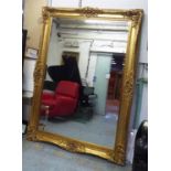 MIRROR, gilt of large proportions with a bevelled plate and scroll and flowerhead decoration,