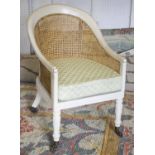 BERGERE, Regency style cream painted and caned with patterned green seat cushion on castors, 58cm W.