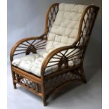 CONSERVATORY ARMCHAIR, mid 20th century woven rattan with bowed arms and three seats cushions,