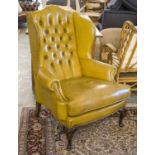 WING ARMCHAIR, Georgian style in olive green leather with cushion seat, 110cm H x 82cm W.