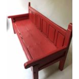 ANTIQUE BENCH, red painted pine with panelled back and arms, 170cm W.