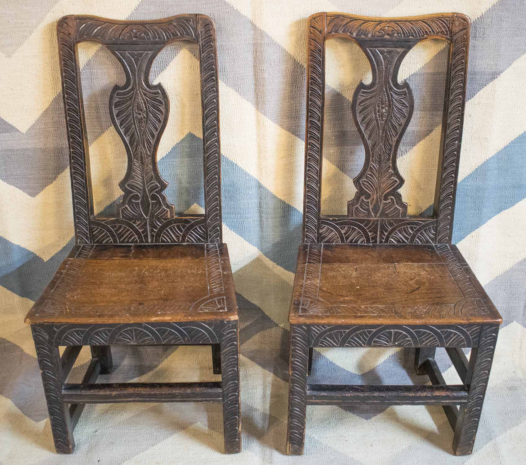 SIDE CHAIRS, a pair, early 18th century elm with all over carving.