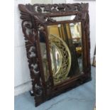 WALL MIRROR, late 19th century Flemish oak with leaf and scroll decorated cushion frame,
