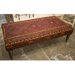 HEARTH STOOL, dark red kilim upholstered on ball turned legs, 43cm H x 140cm W x 70cm D.