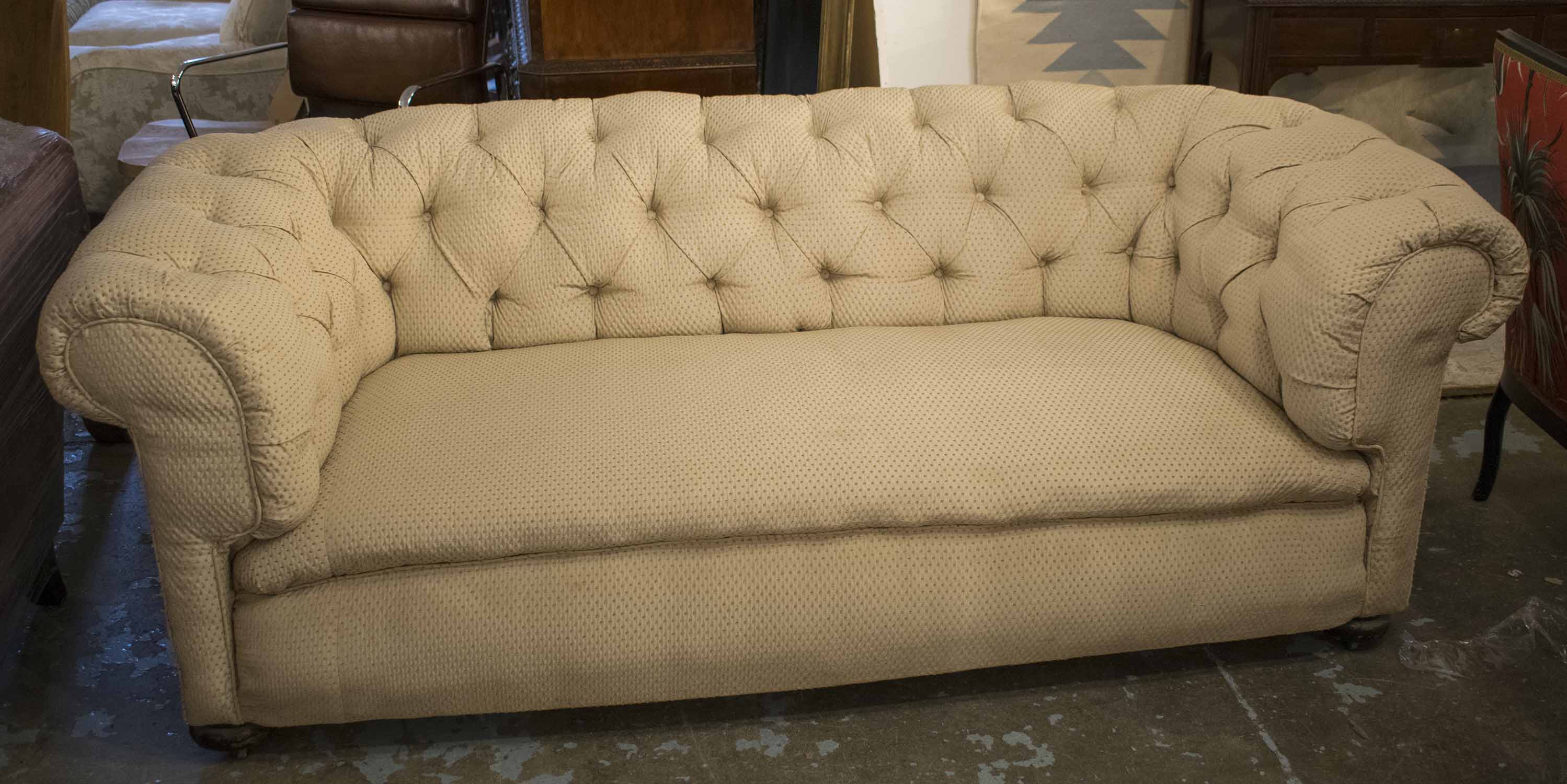 CHESTERFIELD SOFA, early 20th century in patterned cream material on castors, 207cm W.