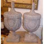 URNS, a pair, George III style, lead effect, each with a turned finial and swag decoration,