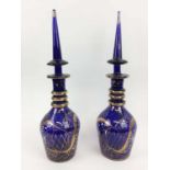 BOHEMIAN BLUE GLASS DECANTERS, a pair, Persian design, colbolt blue ground etched and hand painted