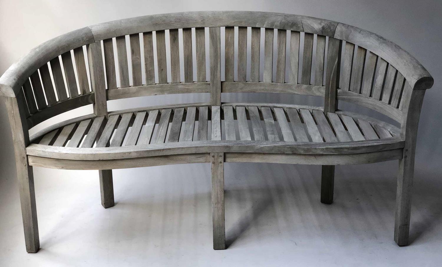 GARDEN BENCH, banana design, silvery weathered teak of bowed form and slatted construction, 160cm W.