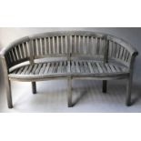 GARDEN BENCH, banana design, silvery weathered teak of bowed form and slatted construction, 160cm W.