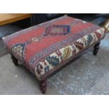 FOOTSTOOL, English country house style, upholstered in a vintage carpet, on turned supports, 63cm