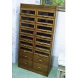 HABERDASHERY CABINET, oak with fourteen glazed fronted drawers above four drawers, 93cm W x 188cm