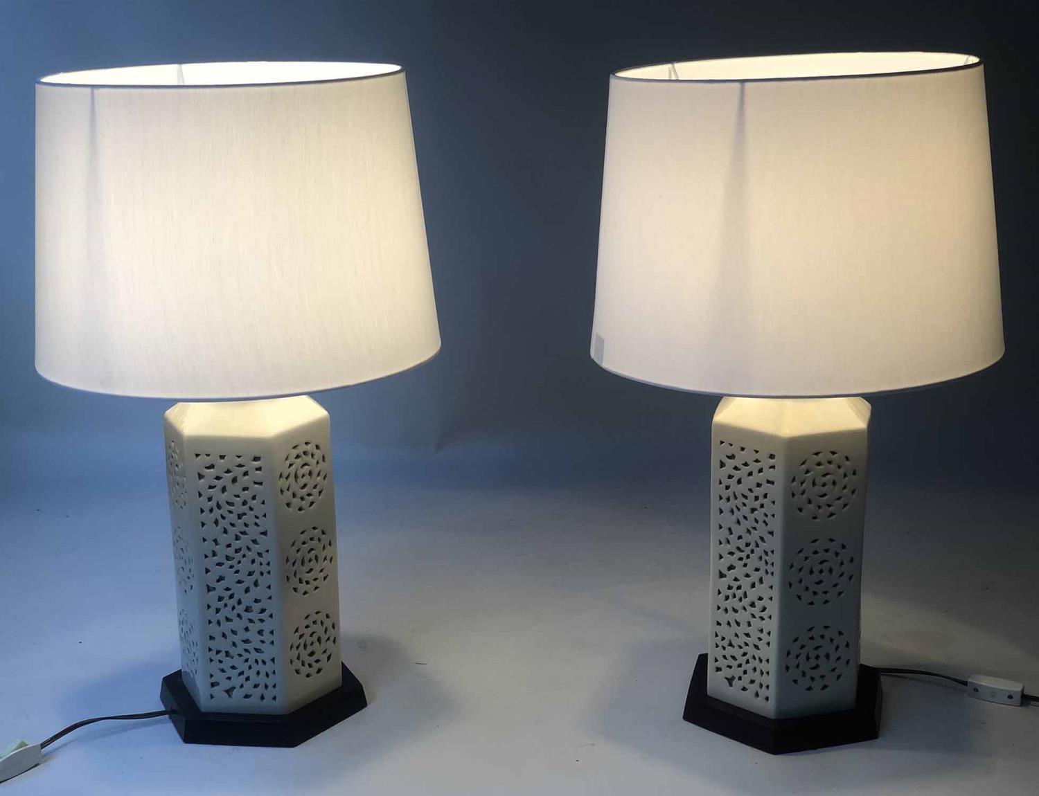 RETICULATED LAMPS, a pair, Chinese hexagonal pierced ivory coloured ceramic on wooden stands, 70cm H