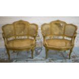 FAUTEUILS, a pair, late 19th century French giltwood and caned with wide gold plush squab