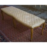 LONG STOOL, early 20th century French walnut with buttoned cream upholstery, 49cm x 154cm L. (with