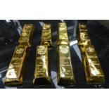 FAUX GOLD BULLION BARS, a set of eight, 24cm x 8.5cm x 4cm. (8)