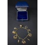 CHARM BRACELET, vintage 9ct yellow gold linked charm bracelet set with 9 yellow gold charms and