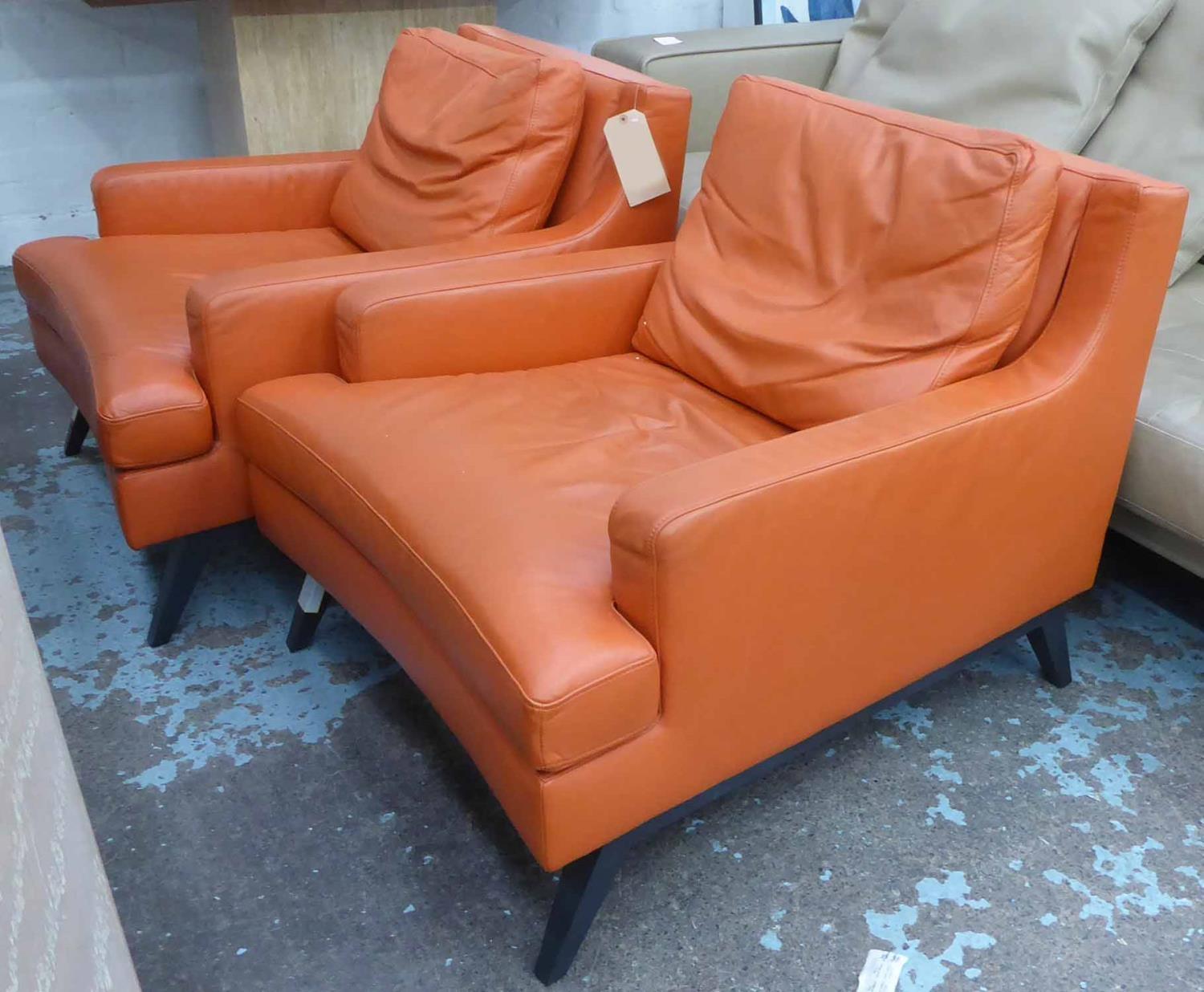 LIGNE ROSET ARMCHAIRS, a pair, orange leather upholstered, 80cm x 93cm x 72cm H. (2)