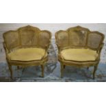 FAUTEUILS, a pair, late 19th century French giltwood and caned with wide gold plush squab