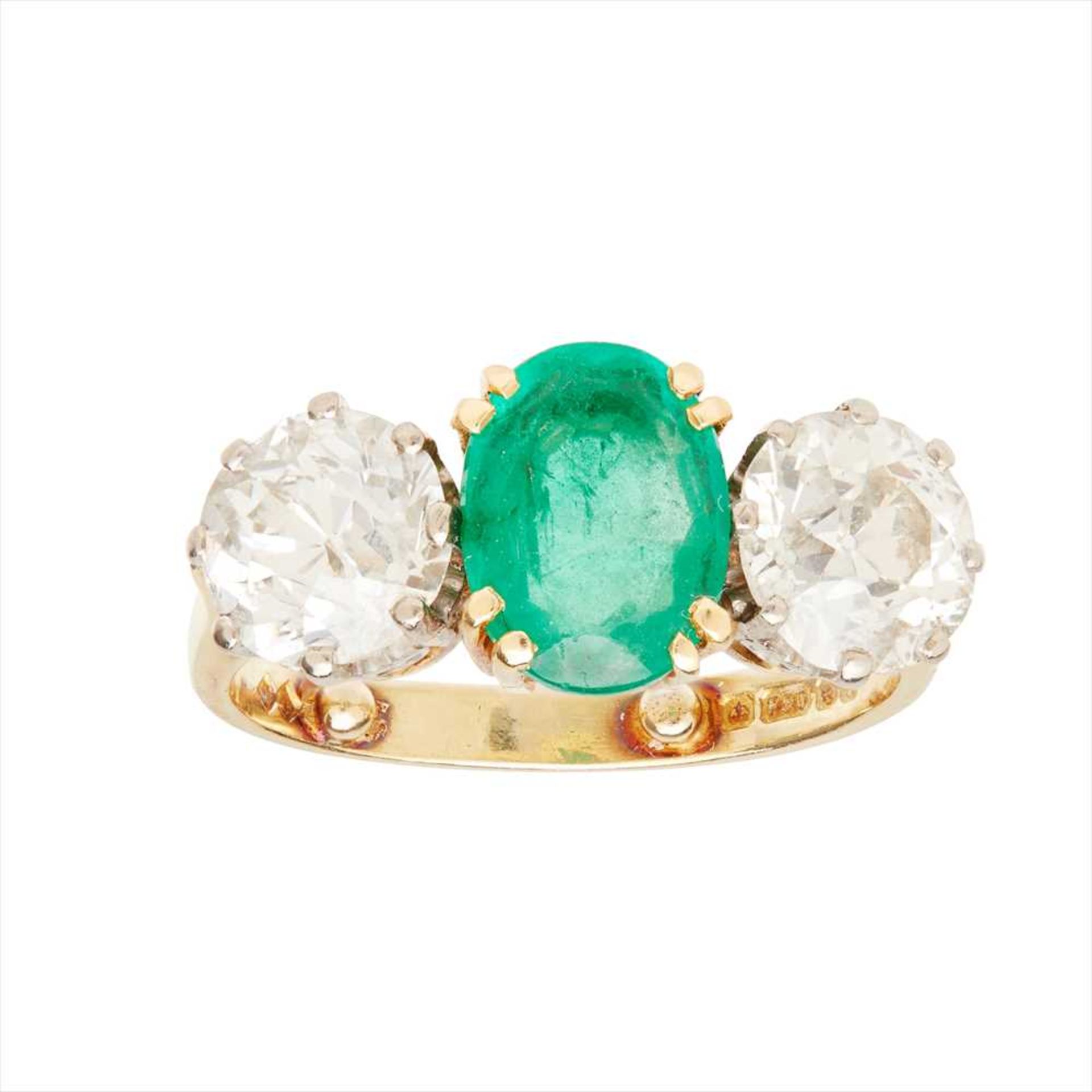 An emerald and diamond set three stone ring
