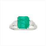 An emerald and diamond set three stone ring